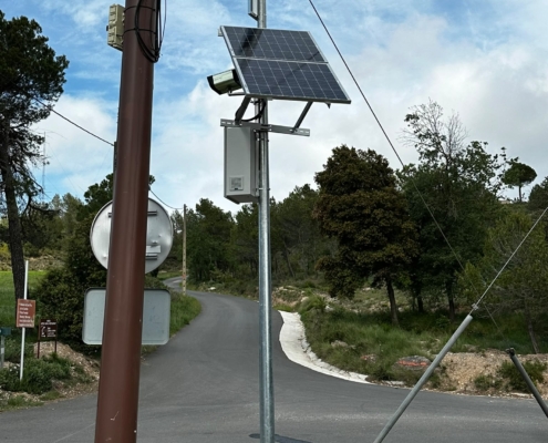 Instalación de mástil metálico exterior con panel solar y equipos de telecomunicaciones para enlaces inalámbricos en polígonos industriales