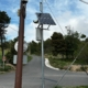 Instalación de mástil metálico exterior con panel solar y equipos de telecomunicaciones para enlaces inalámbricos en polígonos industriales