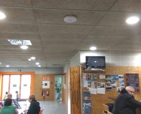Punto de acceso WiFi en techo — roaming entre zonas en espacio compartido